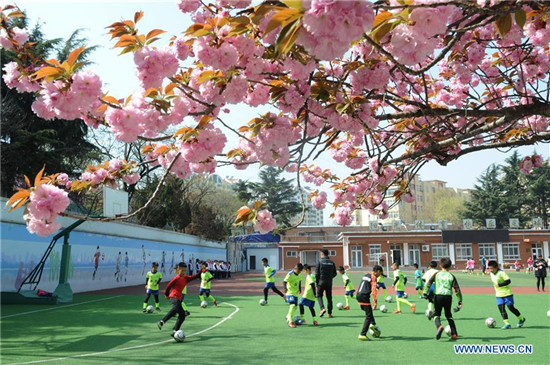 Pupils take part in football training in elementary school in Qingdao